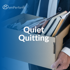A person holding a cardboard box filled with office items. Text on top says Quiet Quitting.